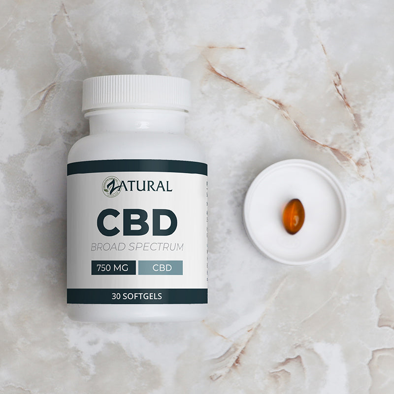 CBD supplement bottle with a softgel on a marble surface