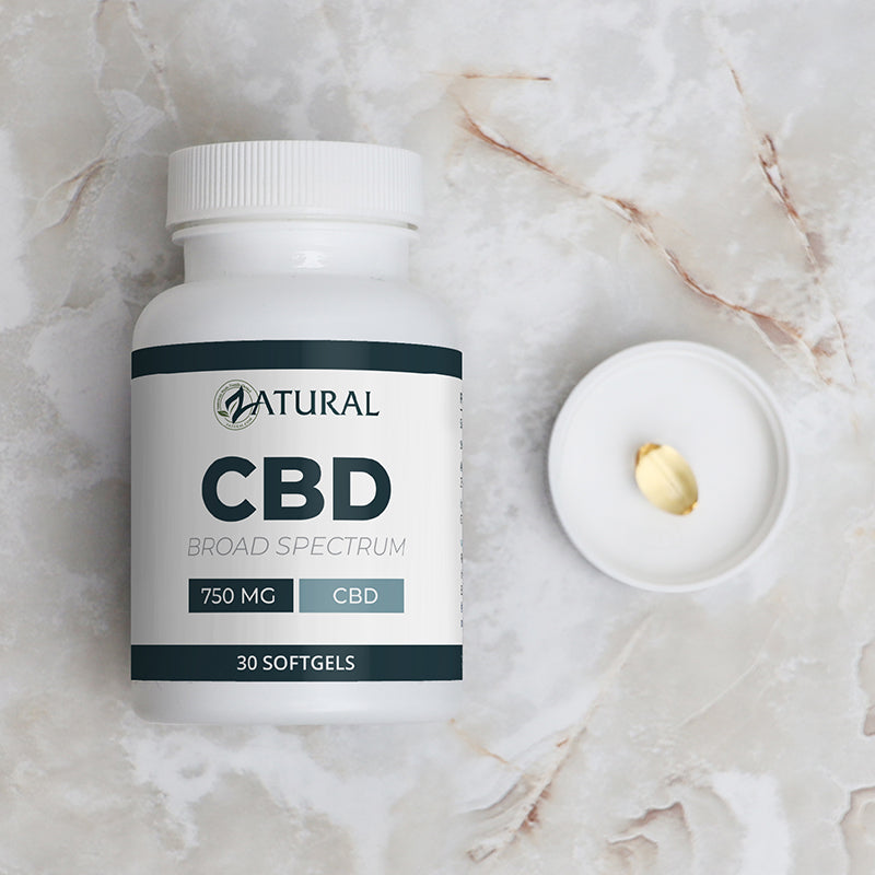 CBD supplement bottle labeled 'Natural' on a marble surface with a softgel capsule.