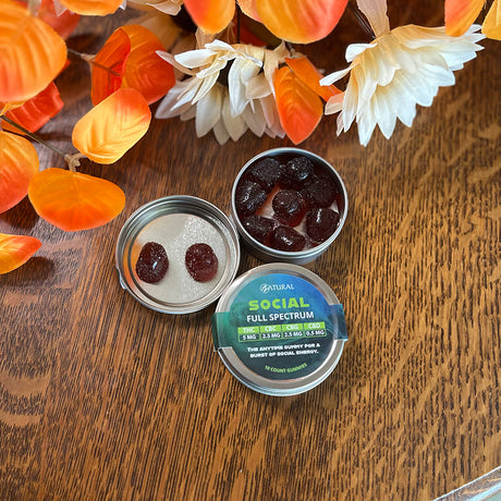 Social Gummies with a label on a wooden surface with autumn leaves.
